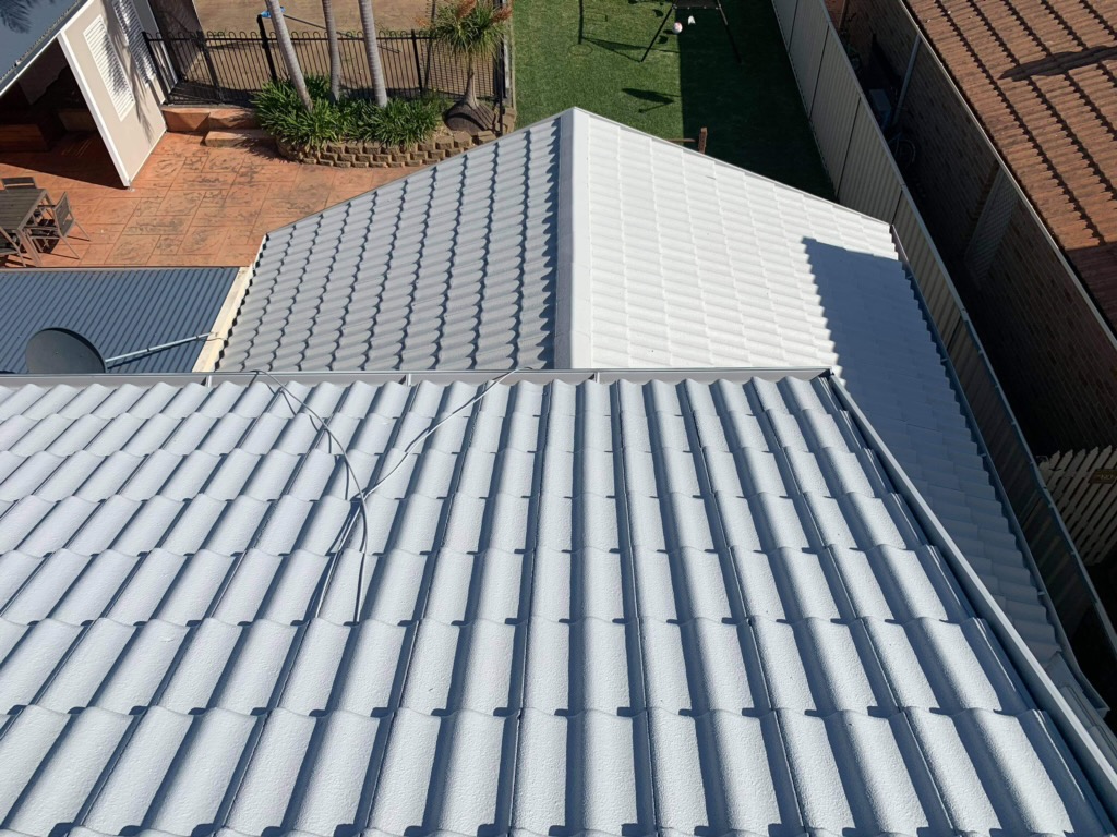 The same roof after restoration, repainted in an even light grey finish