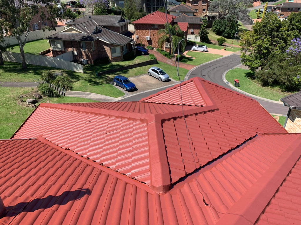 Completed roof restoration with the tiles repainted in a terracotta red finish