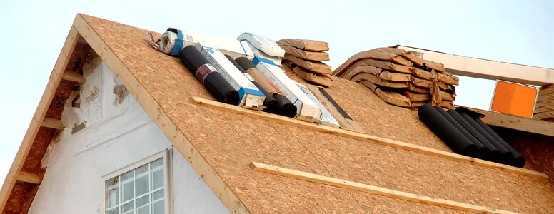 Close-up of a tiled roof surface showing weathering and moss build-up